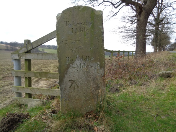 The side of the stone pillar that had directions/mileages and the Bench Mark at the junction of Eccup Lane and High Weardley Lane, Leeds (taken on Leap Year Day Feb 29 2016).