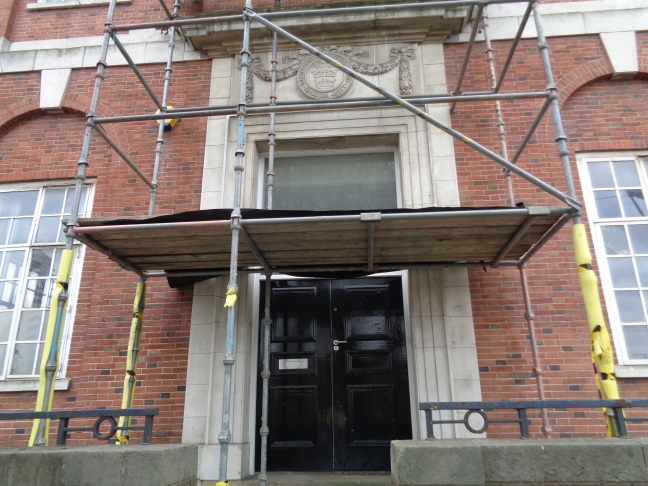View of the doorway with the plaque and some scaffolding (taken April 5 2106).